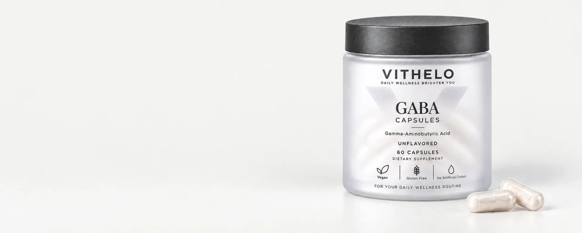 VITHELO GABA Capsules bottle and hard capsules on the right of a continuous pale-gray horizontal studio scene.